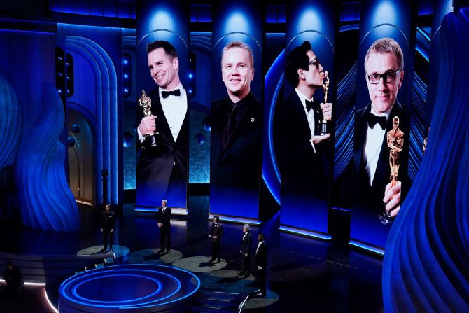 From left, Sam Rockwell, Tim Robbins, Ke Huy Quan, Christoph Waltz and Mahershala Ali present the nominees for best supporting actor.