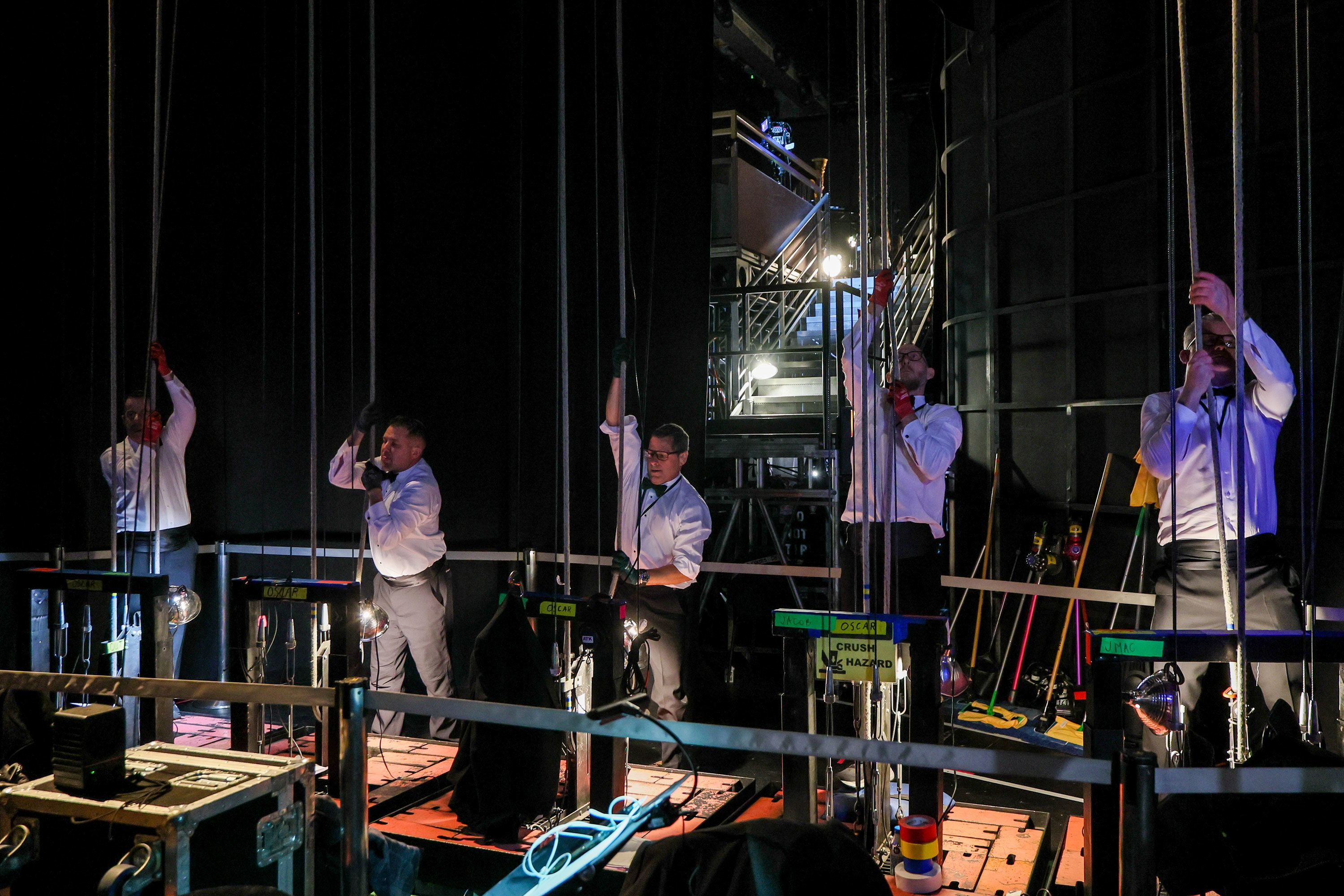 Curtain operators work backstage during the show.