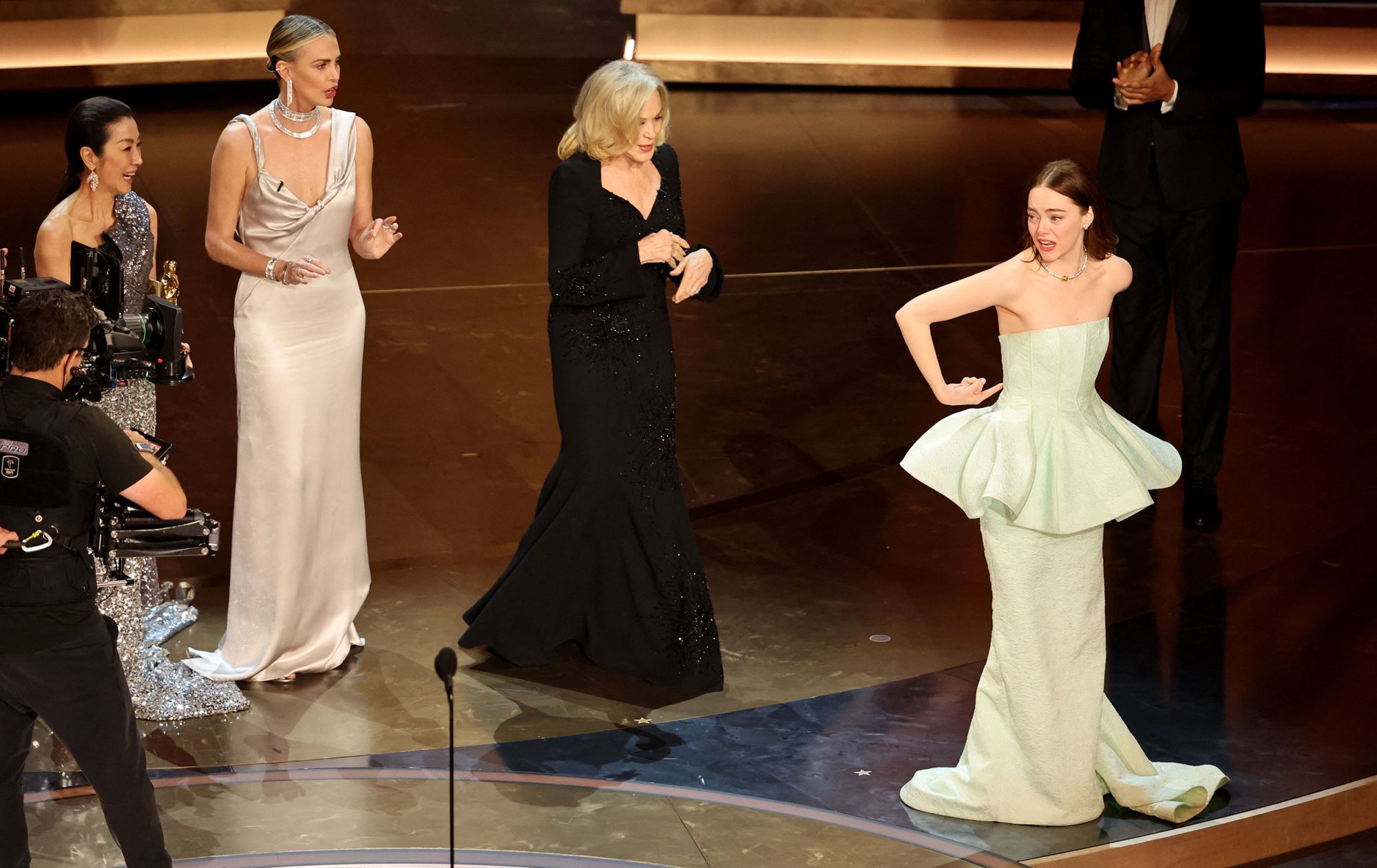 Emma Stone gestures toward her dress as she wins the Oscar for Best Actress for "Poor Things" during the Oscars show at the 96th Academy Awards in Hollywood, Los Angeles, California, U.S., March 10, 2024. REUTERS/Mike Blake