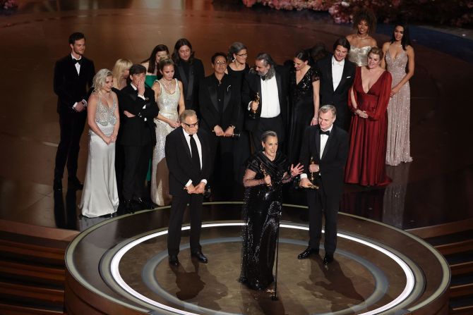 Producer Emma Thomas speaks on stage after "Oppenheimer" won the Academy Award for best picture on Sunday, March 10. At front right is her husband, Christopher Nolan, who also won the Oscar for best director.