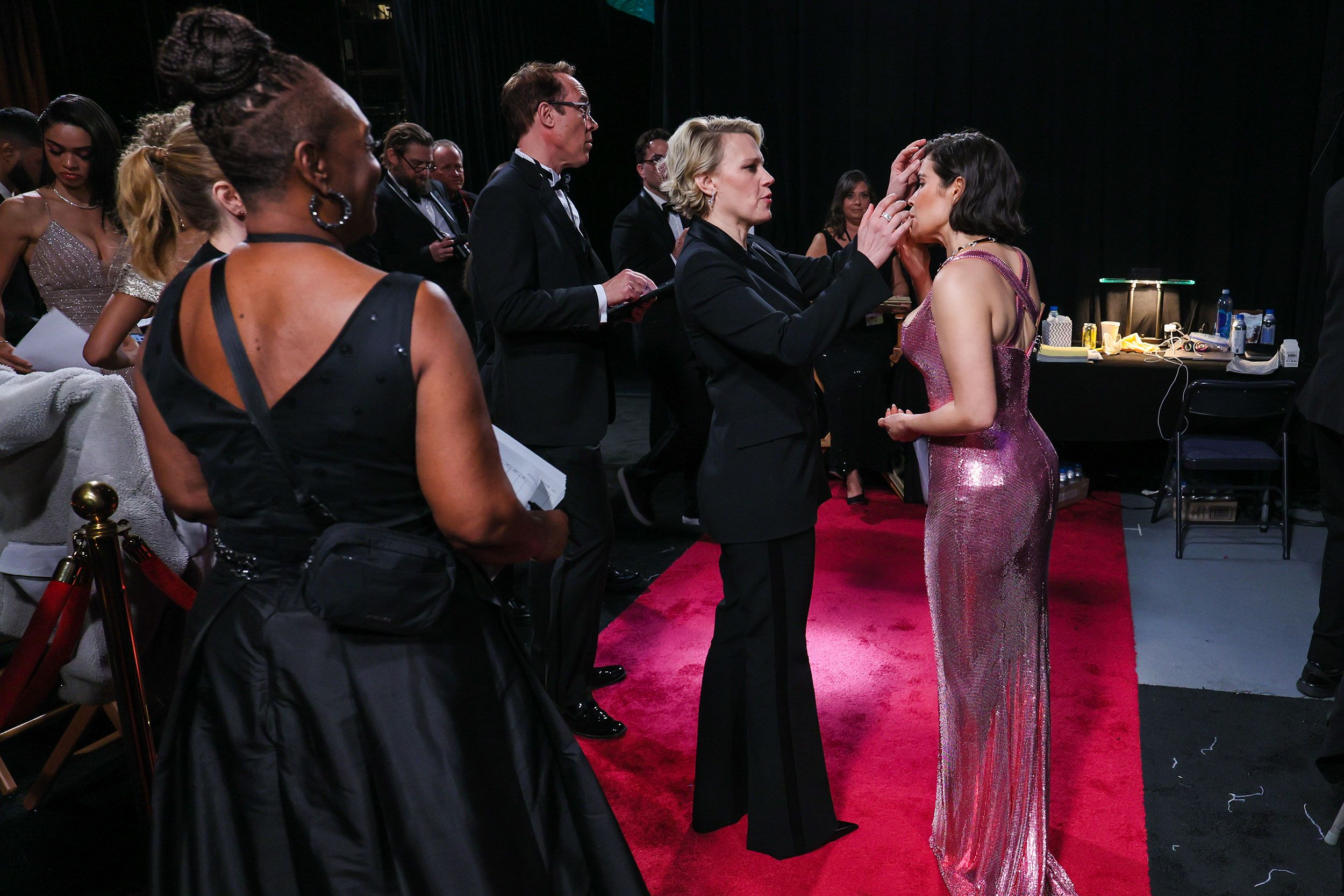 Kate McKinnon helps her "Barbie" co-star America Ferrera backstage.