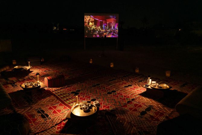<strong>Cinematic: </strong>The nearby outdoor cinema screens classic movies beneath the desert night sky, while guests lounge by a fire pit in a cozy area strewn with traditional rugs and handwoven pillows.