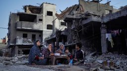 The Palestinian Al-Naji family eats an iftar meal, the breaking of fast, amidst the ruins of their family house, on the first day of the Muslim holy fasting month of Ramadan, in Deir el-Balah in the central Gaza Strip on March 11, 2024, amid ongoing battles between Israel and the militant group Hamas.