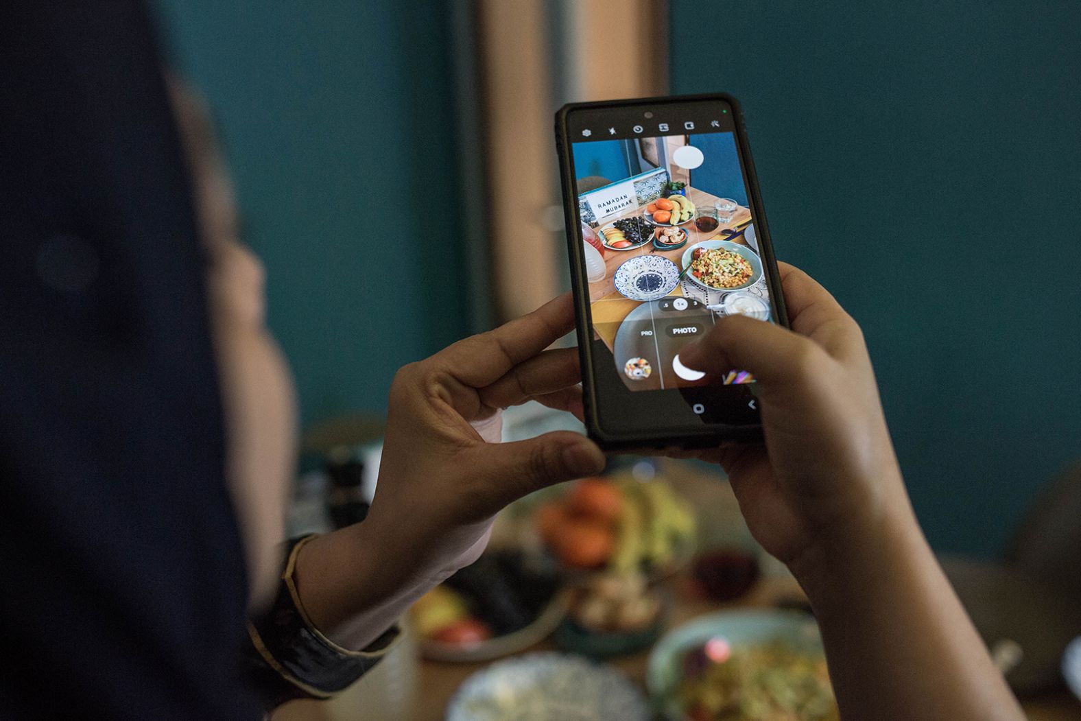 A woman takes a photo of a meal before iftar in Hamburg, Germany.