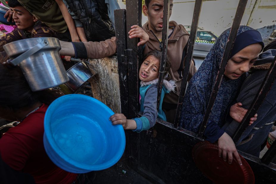 Displaced Palestinians gather to collect food donated by a charitable youth group in Rafah, Gaza, on March 12. It was the second day of the holy month of Ramadan.