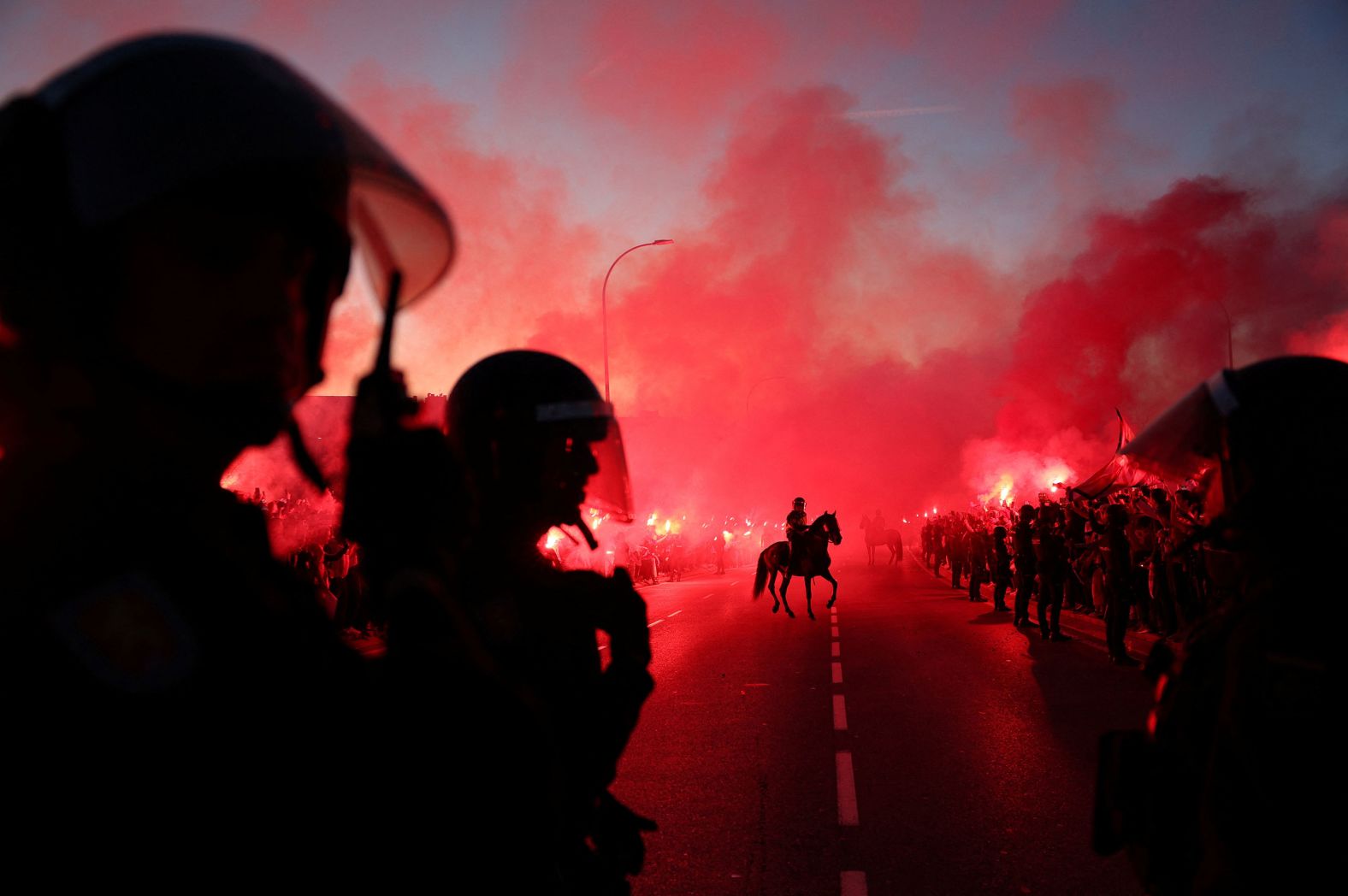 Police officers work outside Madrid's Metropolitano Stadium, where fans lit flares before a <a href="index.php?page=&url=https%3A%2F%2Fwww.cnn.com%2F2024%2F03%2F14%2Fsport%2Fatletico-madrid-champions-league-quarterfinals-spt-intl%2Findex.html" target="_blank">Champions League match</a> between Atlético Madrid and Inter Milan on Wednesday, March 13.
