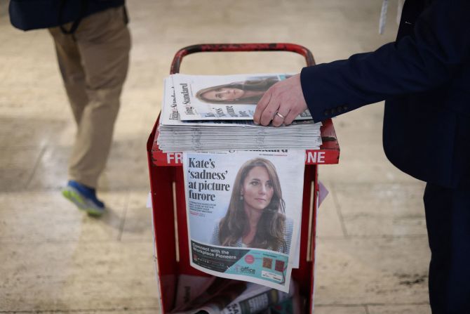 A commuter picks up a copy of the Evening Standard, featuring a cover story on Catherine, the Princess of Wales, at a subway station in London on Tuesday, March 12. This was after several major news agencies <a href="index.php?page=&url=https%3A%2F%2Fwww.cnn.com%2F2024%2F03%2F10%2Fuk%2Fnews-agencies-recall-image-of-catherine-princess-of-wales%2Findex.html" target="_blank">had withdrawn a photo</a> distributed by Kensington Palace showing Catherine and her children, saying they believed the photo had been manipulated. In a statement, <a href="index.php?page=&url=https%3A%2F%2Fwww.cnn.com%2F2024%2F03%2F11%2Ftech%2Fphoto-editing-kate-middleton%2Findex.html" target="_blank">Catherine acknowledged that she used an editing tool or tools</a> to alter the image.