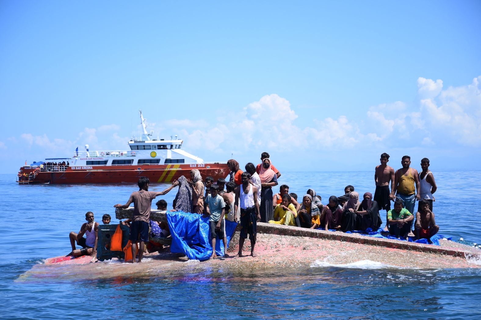 Rohingya refugees wait to be rescued from the hull of their capsized boat as a rescue vessel approaches off West Aceh, Indonesia, on Thursday, March 21.