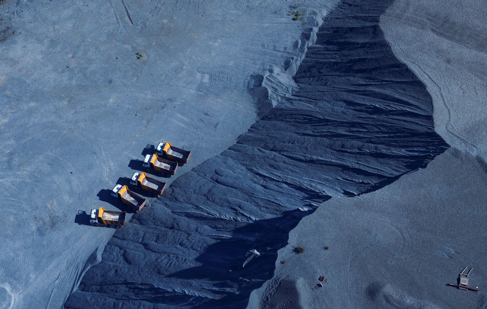 Trucks wait to load chrome at a mine in Marikana, South Africa, on Thursday, March 14.