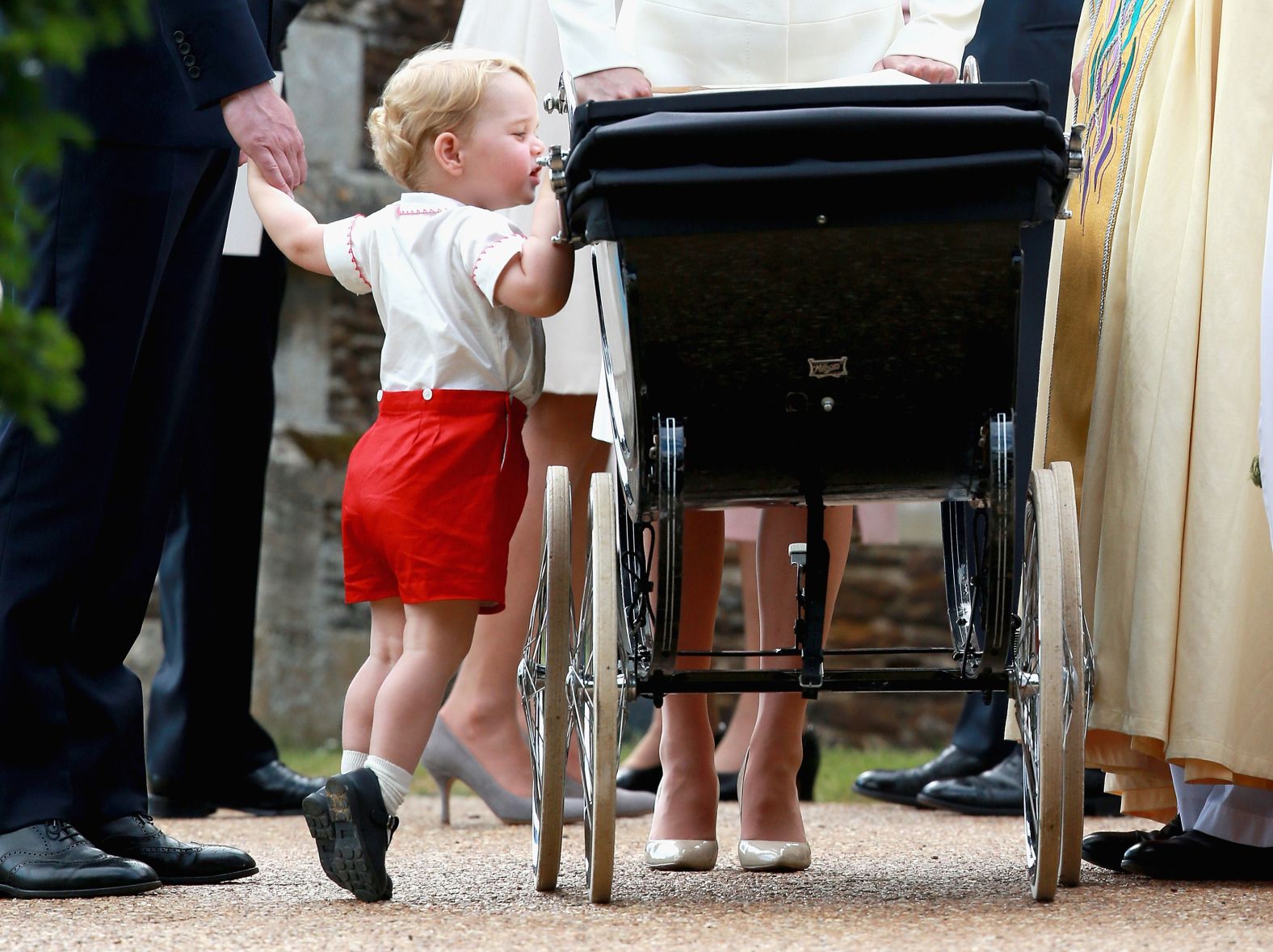 Prince George looks at his newborn sister, Princess Charlotte, as the family departs her christening in 2015.