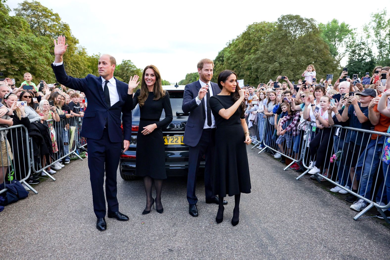 From left, Prince William, Kate, Prince Harry and Meghan, the Duchess of Sussex, wave to a crowd outside Windsor Castle ahead of the Queen's funeral in 2022.