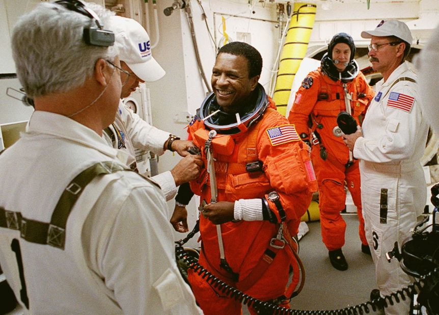 Members of the closeout crew help Anderson, front, with his launch and entry suit in the White Room at Kennedy Space Center in Florida on January 16, 2003. The environmentally controlled chamber was mated to Space Shuttle Columbia for access into the orbiter. Behind Anderson is McCool.