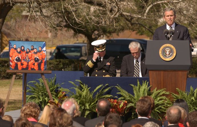 Capt. Gene Theriot, chaplain for the US Navy Corps, wipes his eyes as he and NASA administrator Sean O'Keefe listen to President George W. Bush speak during a memorial service at the Johnson Space Center in Houston on February 4, 2003. On Theriot's right is a portrait of the STS-107 crew. "To leave behind Earth and air and gravity is an ancient dream of humanity," <a href="index.php?page=&url=https%3A%2F%2Fwww.c-span.org%2Fvideo%2F%3F174923-1%2Fspace-shuttle-columbia-memorial-service" target="_blank" target="_blank">President Bush said</a>. "For these seven, it was a dream fulfilled. Each of these astronauts had the daring and discipline required of their calling. Each of them knew that great endeavors are inseparable from great risks. And each of them accepted those risks willingly, even joyfully, in the cause of discovery."