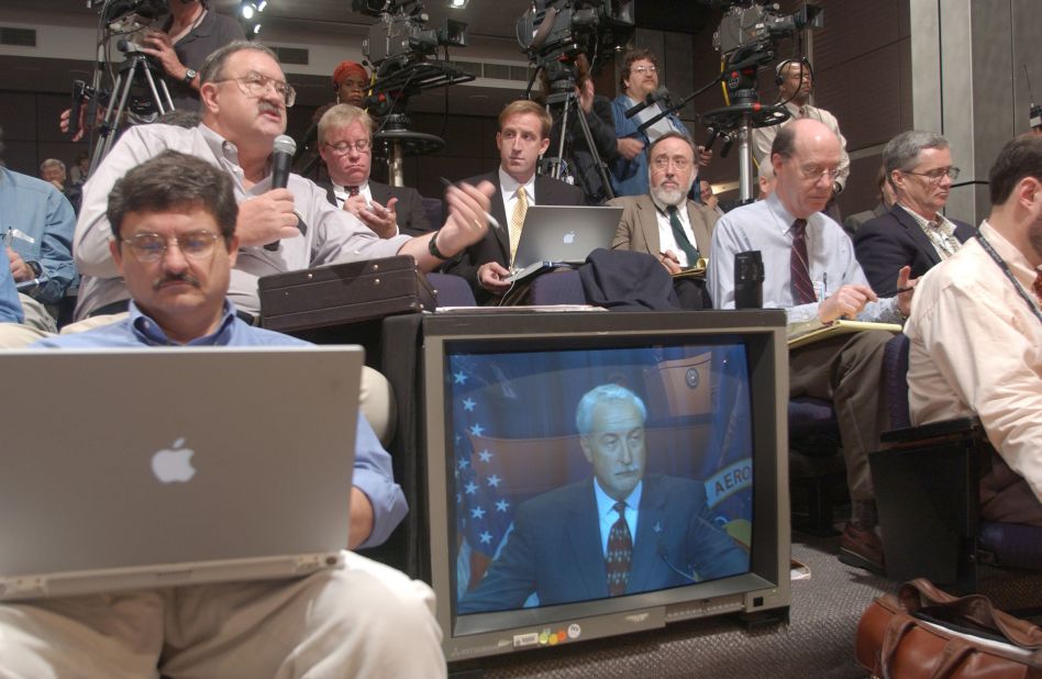 Reporters ask NASA Administrator O'Keefe, visible in the monitor, questions about the "Columbia Accident Investigation Board Report" during a news conference at NASA Headquarters in Washington, DC, on August 27, 2003.