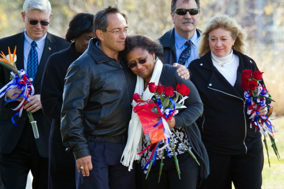 Sandy Anderson, widow of Space Shuttle Columbia's Michael P. Anderson, is comforted by astronaut Carlos Noriega during the annual Day of Remembrance ceremony at the Johnson Space Center's Astronaut Tree Grove in Houston on January 27, 2011. Johnson Space Center Director Michael L. Coats is on the far left, and Evelyn Husband-Thomas, widow of the Columbia crew's Rick D. Husband, is on the right.