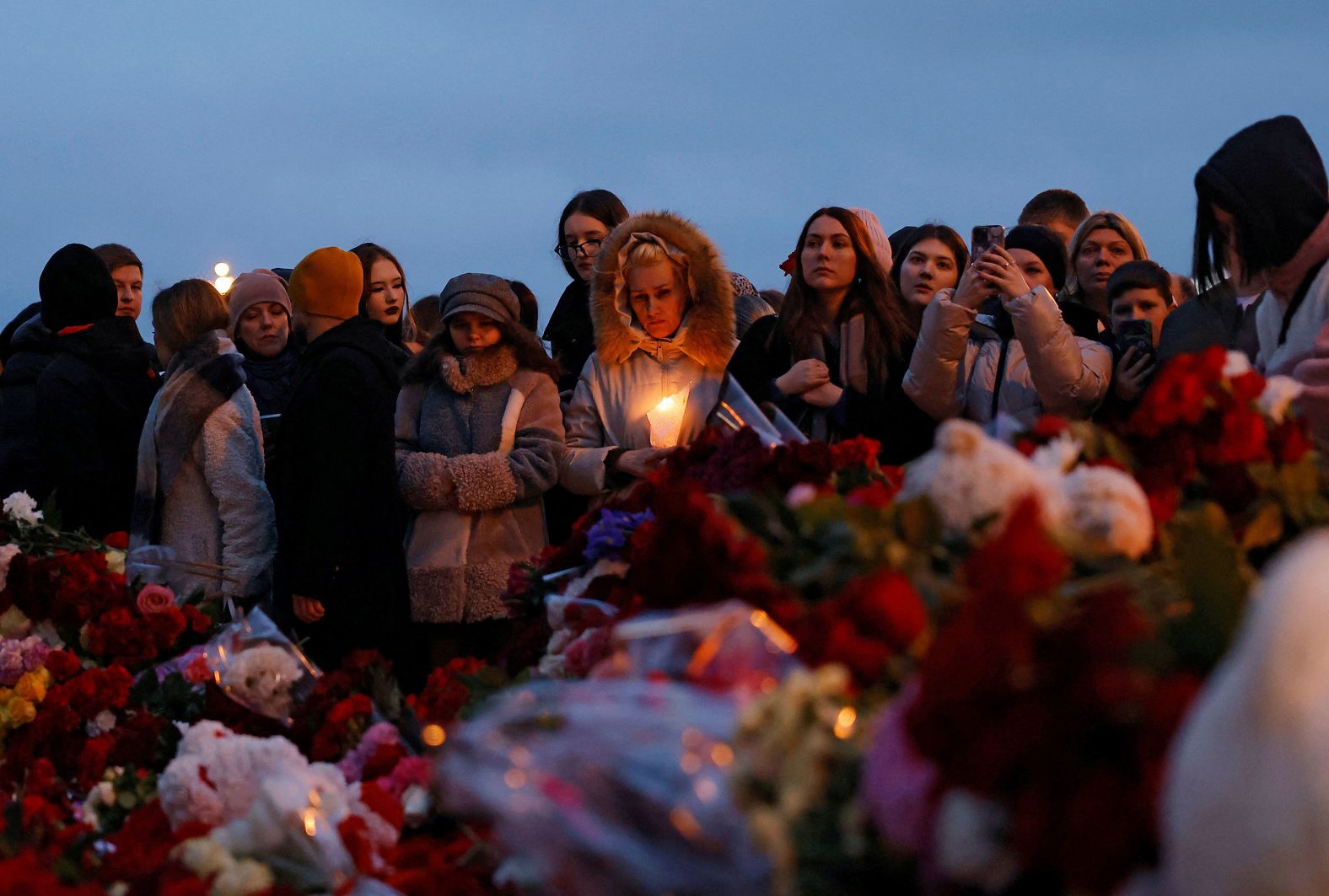 People in Moscow gather at a makeshift memorial outside the Crocus City Hall concert venue on Saturday, March 23, to remember those who were killed in a terrorist attack there the day before.