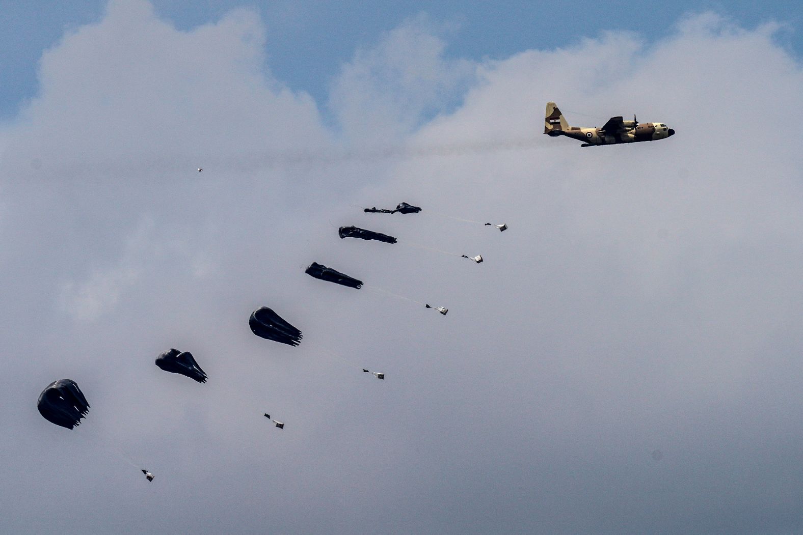 An aircraft airdrops humanitarian aid over northern Gaza on Sunday, March 24. Israel's severe restrictions on aid entering Gaza have drained essential supplies, condemning the entire population of more than 2.2 million people to the risk of famine, according to a UN-backed report.