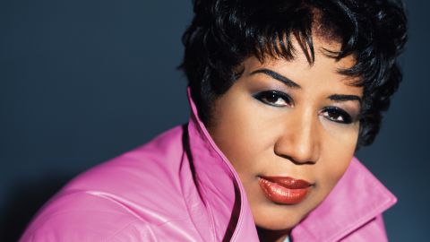 Radiating confidence and style, Aretha Franklin strikes a bold pose, turning up her collar and meeting the lens with a determined gaze. This iconic moment was captured in Detroit, Michigan, on Wednesday, February 2, 2005, during her inaugural photo session with Matthew Jordan Smith. Clad in a vibrant bright pink leather jacket, she exudes cool energy, accentuated by her short crop hair and striking red lipstick.