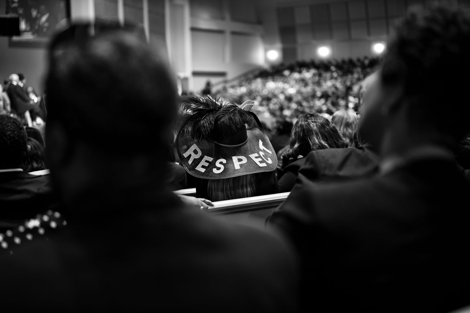 An attendee, paying tribute with a hat reading "RESPECT," watches Franklin's funeral service in Detroit. 