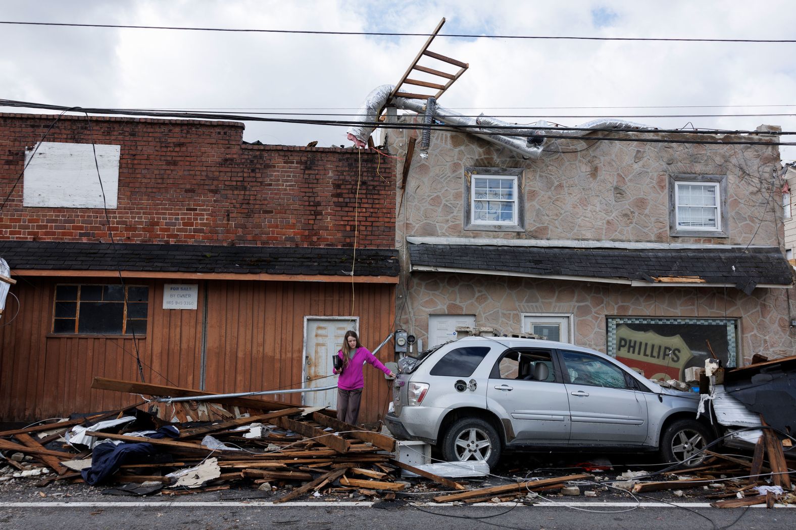 A woman exits a tornado-damaged building in Sunbright, Tennessee, on Wednesday, April 3. <a href="index.php?page=&url=https%3A%2F%2Fwww.cnn.com%2F2024%2F04%2F03%2Fus%2Fpower-outages-ohio-valley-storms-tornadoes%2Findex.html" target="_blank">Sixteen tornadoes were reported Tuesday and Wednesday morning</a> across Illinois, Kentucky, Ohio, Alabama, Tennessee and Georgia.