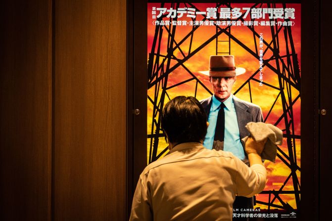 A worker in Tokyo cleans a screen showing an "Oppenheimer" movie poster on Friday, March 29. The Academy Award-winning film <a href="https://www.cnn.com/2024/04/01/style/japan-oppenheimer-release-nuclear-intl-hnk/index.html" target="_blank">finally opened in Japan</a>, eight months after its worldwide release, following concerns about how it might be received in the only country that directly experienced the horror of nuclear weapons.