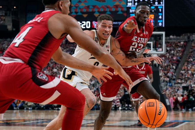Gillis, center, and NC State forward Mohamed Diarra, right, chase down a loose ball.