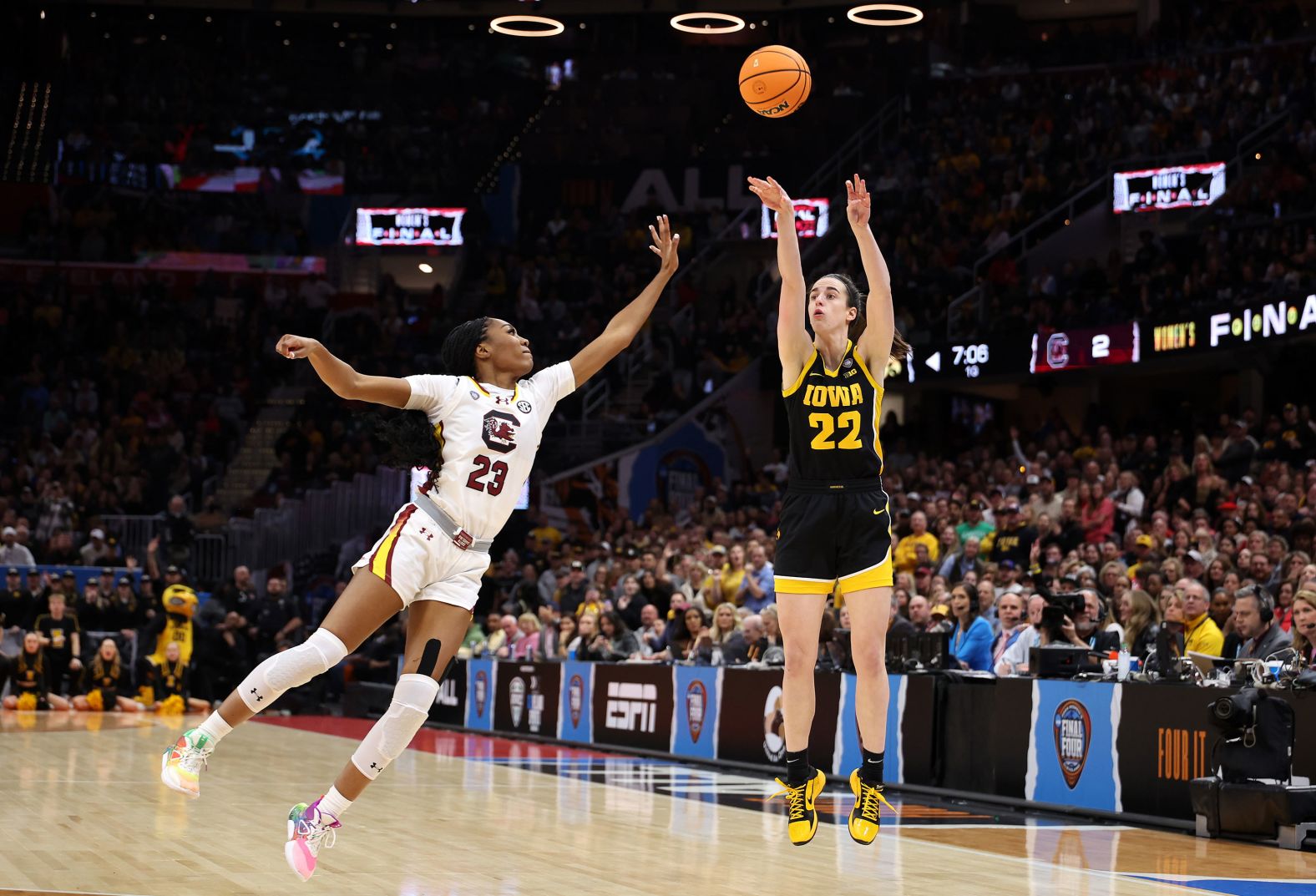 Clark shoots a three-point basket over Hall.