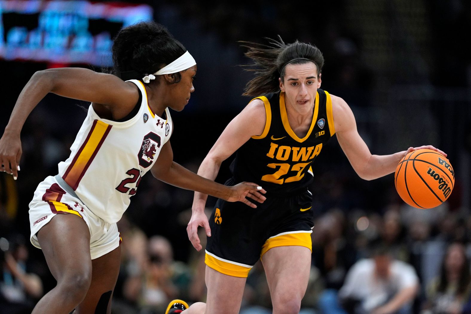 Clark drives up the court past Raven Johnson.