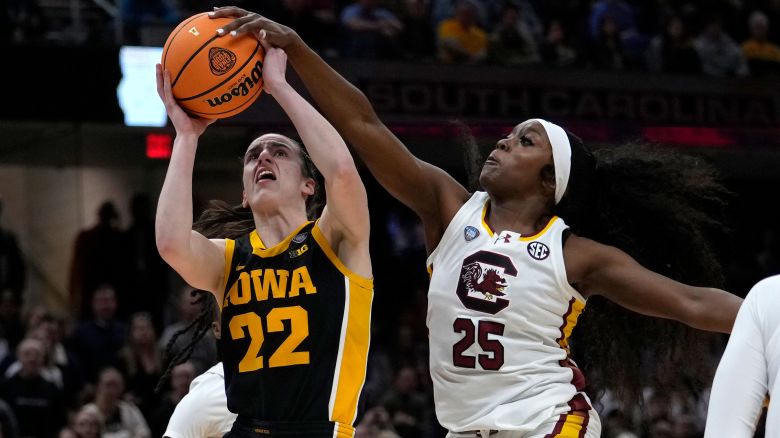 South Carolina guard Raven Johnson (25) blocks a shot by Iowa guard Caitlin Clark (22) during the first half of the Final Four college basketball championship game in the women's NCAA Tournament, Sunday, April 7, 2024, in Cleveland. (AP Photo/Carolyn Kaster)