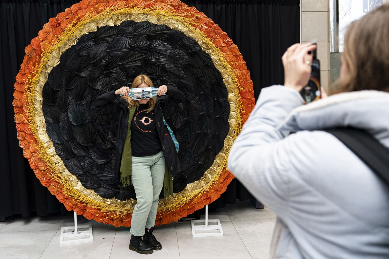 A visitor poses with eclipse glasses during an eclipse viewing event at Niagara Falls.