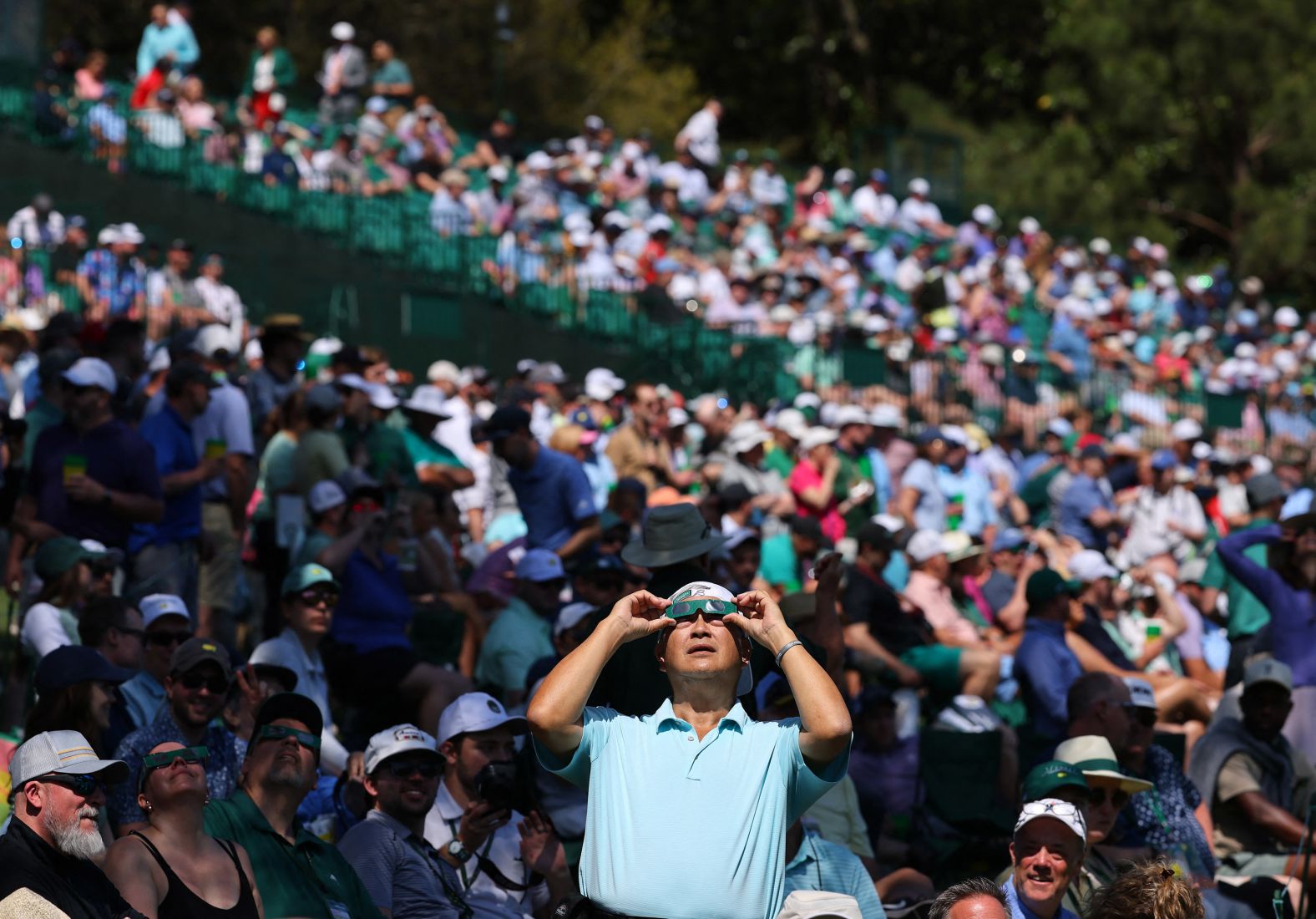 People watch the eclipse from the Augusta National Golf Club in Georgia, where practice rounds were being held ahead of the Masters tournament.