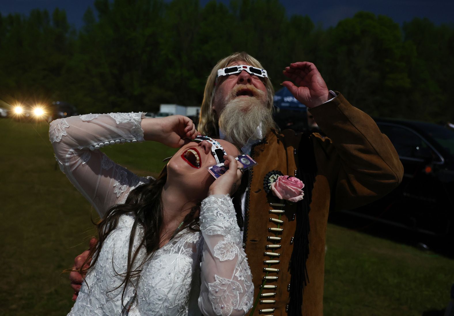 A newly married couple views the eclipse after a <a href="index.php?page=&url=https%3A%2F%2Fwww.cnn.com%2Fworld%2Flive-news%2Ftotal-solar-eclipse-04-08-24-scn%2Fh_c5bf02a1f61852f076e1c082cd6f6290" target="_blank">mass wedding</a> in Russellville, Arkansas. They were one of 358 couples who tied the knot at an "Elope at the Eclipse" event.