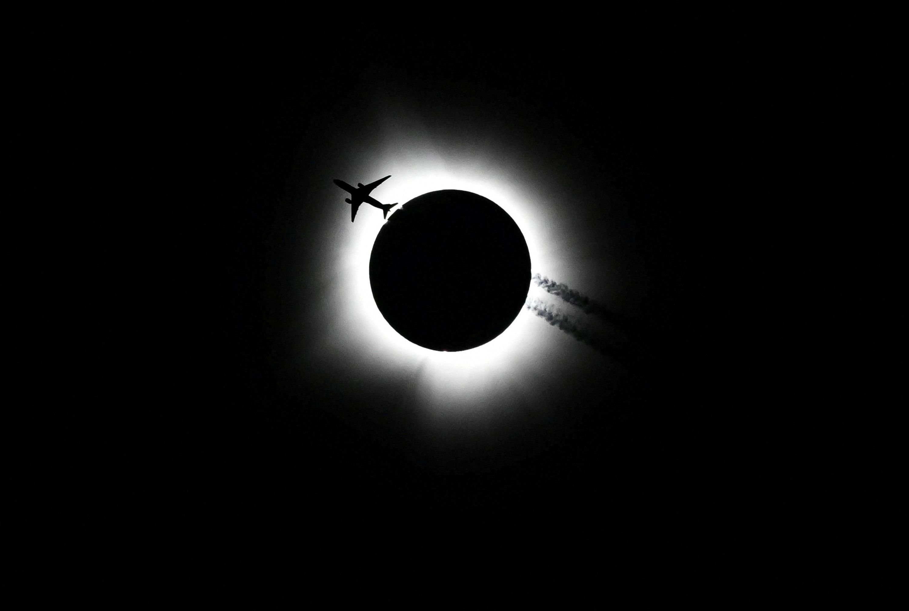 An airplane passes by as the total solar eclipse is seen from Bloomington, Indiana, on Monday, April 8.