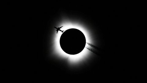 An airplane passes near the total solar eclipse during the Hoosier Cosmic Celebration at Memorial Stadium in Bloomington, Indiana, U.S. April 8, 2024. Bobby Goddin/USA Today Network via REUTERS