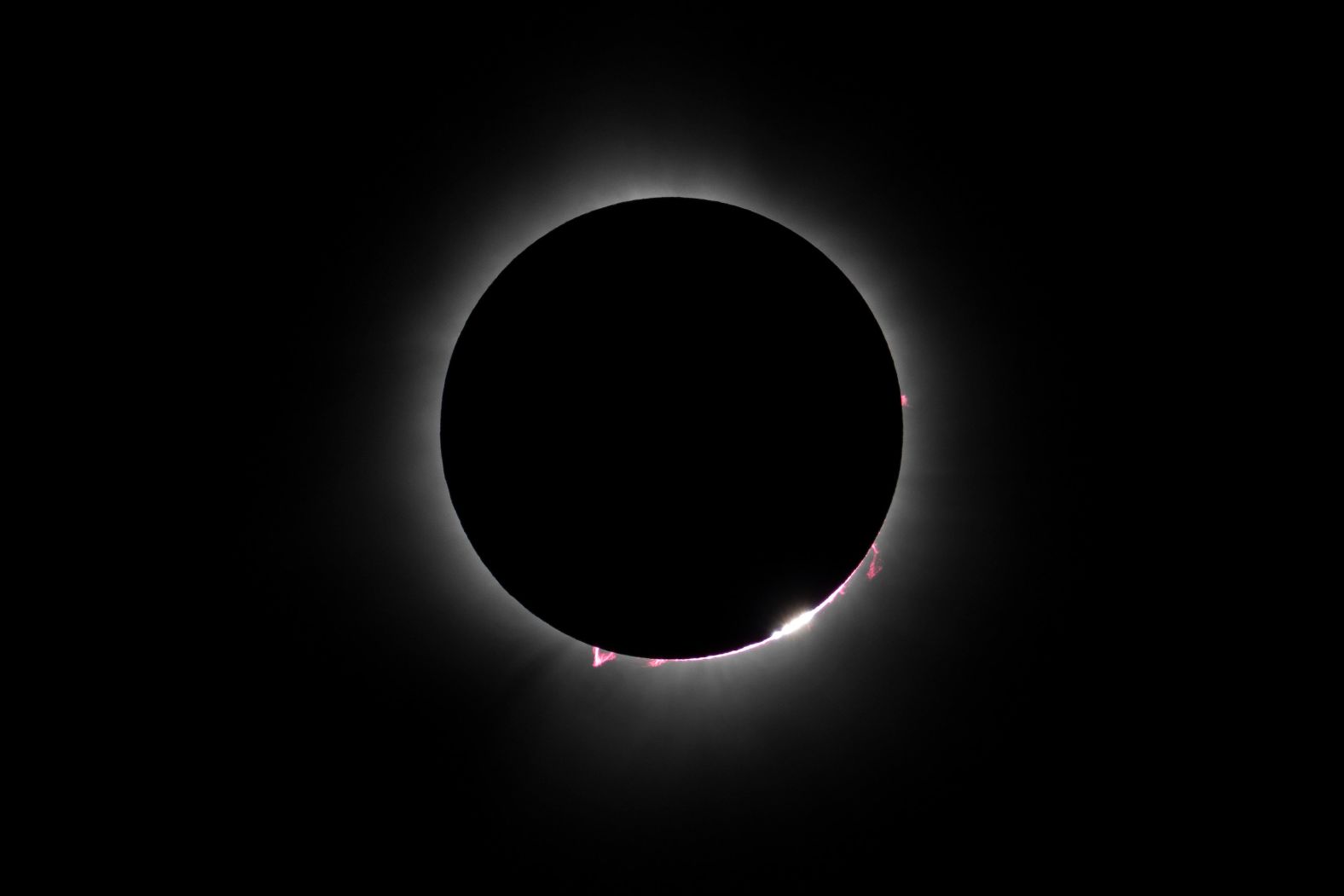 The Baily's Beads effect and red prominences coming off the sun are pictured during the eclipse as seen from Magog.