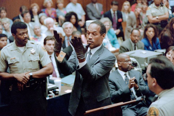 O.J. Simpson shows a new pair of gloves which prosecutors had him put on for the jury during his double murder trial in Los Angeles in June 1995. The gloves were the same type found at the Bundy murder scene and the O.J. Simpson estate.