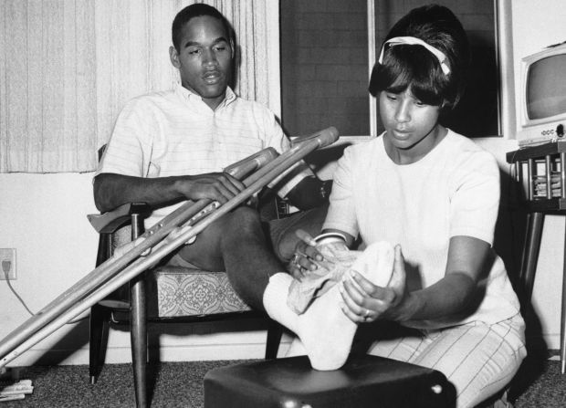 Simpson gets ice applied to his bandaged right foot from his wife Marguerite in 1967.