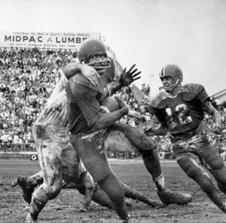 Simpson is brought down by another football player during the Hula Bowl in 1969.