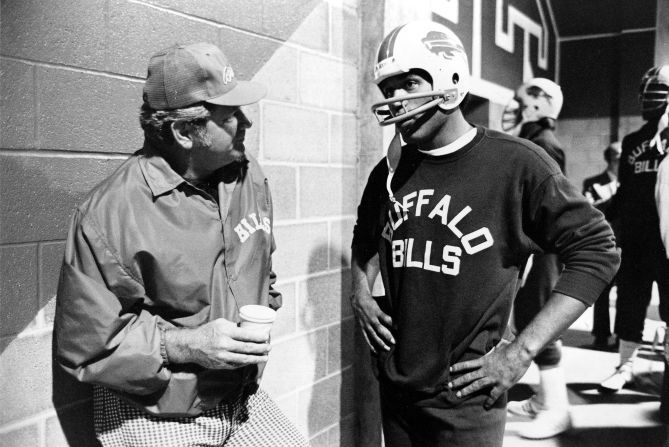 Simpson talks with coach Jim Ringo before a workout in 1976.