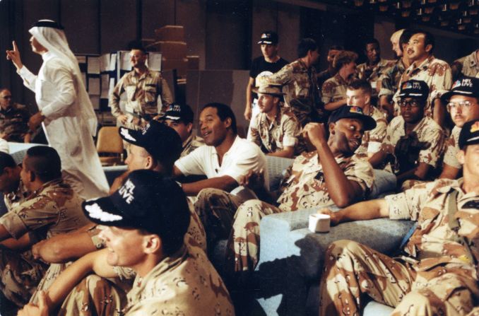 Simpson watches a Thanksgiving Day football game with United States troops deployed oversees during Operation Desert Shield in 1991. 