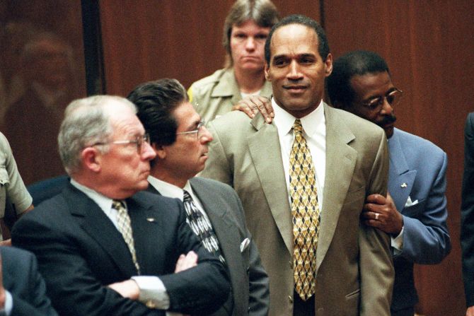 Attorney Johnnie Cochran, Jr. holds Simpson as the not guilty verdict is read in the courtroom on October 3, 1995.