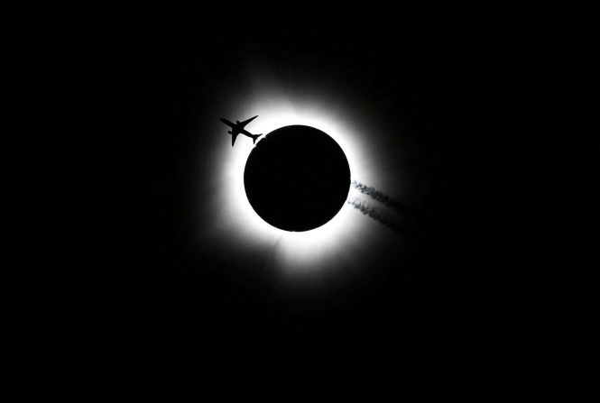 An airplane passes by as the <a href="https://www.cnn.com/2024/04/08/world/gallery/solar-eclipse-photos/index.html" target="_blank">total solar eclipse</a> is seen from Bloomington, Indiana, on Monday, April 8.