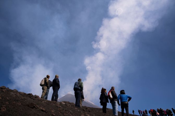 People watch volcanic vortex rings emerge from a new crater on Mt. Etna in Sicily, Italy, on Friday, April 5.