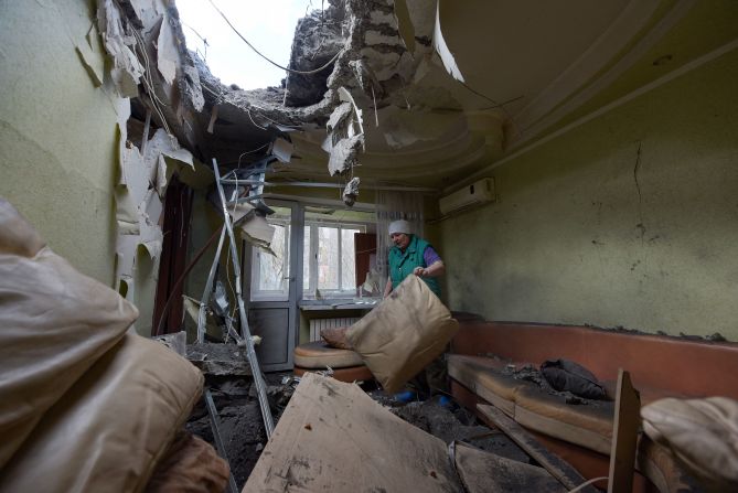A woman clears rubble in her daughter's apartment, which was damaged from shelling in Donetsk, Ukraine, on Thursday, April 4.
