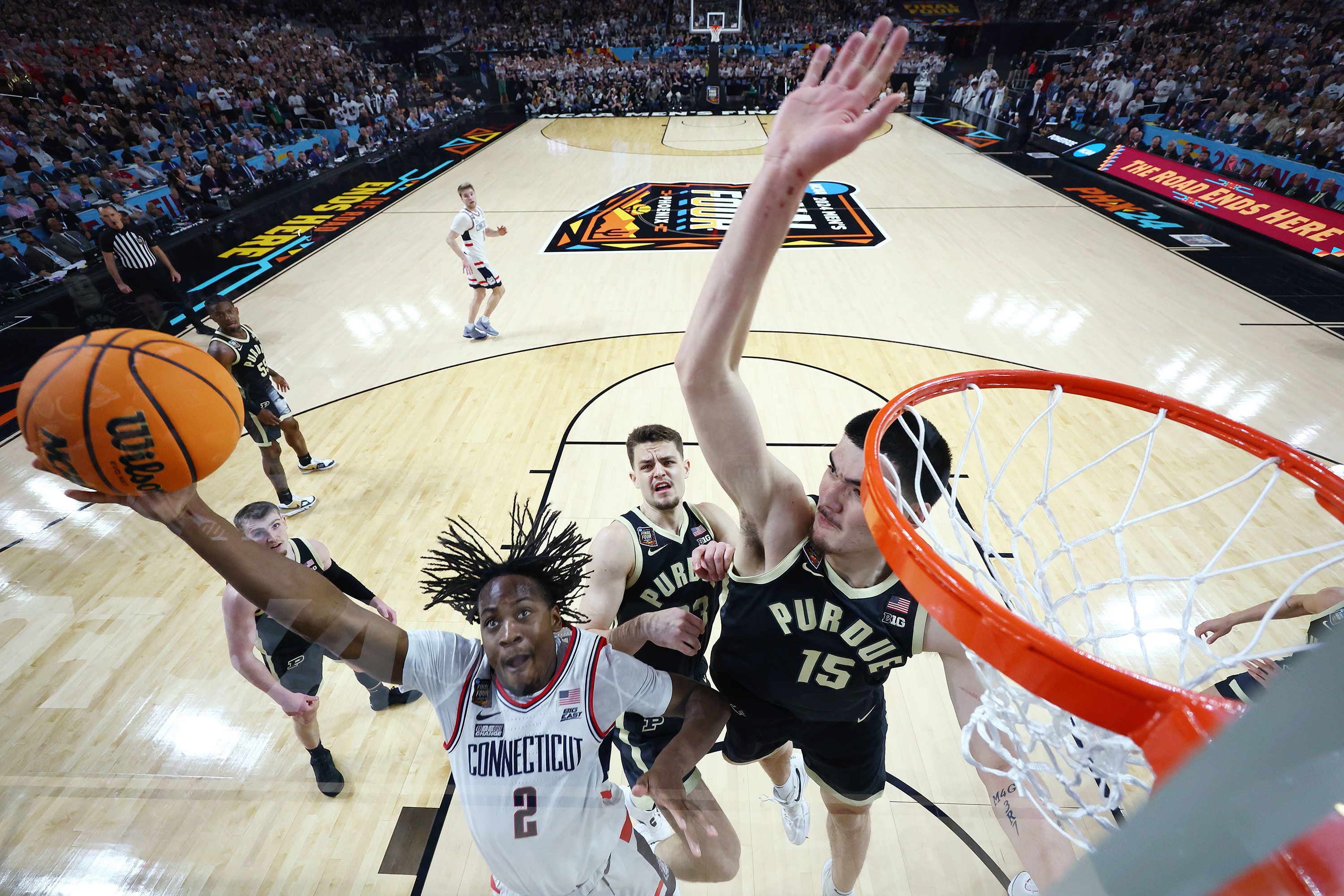 UConn guard Tristen Newton attempts a layup over Purdue's Zach Edey during the NCAA men's basketball national championship game on Monday, April 8, in Phoenix, Arizona.