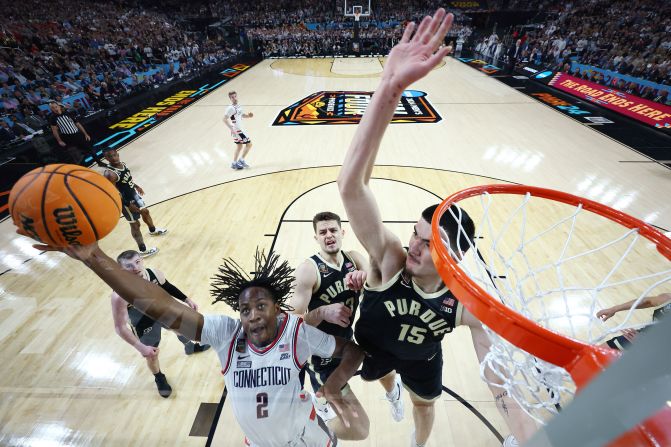 UConn guard Tristen Newton attempts a layup over Purdue's Zach Edey during the NCAA <a href="https://www.cnn.com/2024/04/07/sport/gallery/ncaa-mens-final-four-2024/index.html" target="_blank">men's basketball national championship game</a> on Monday, April 8, in Phoenix, Arizona. UConn defeated Purdue 75-60 to win its <a href="https://www.cnn.com/2024/04/09/sport/uconn-ncaa-basketball-title-hurley-purdue-spt-intl/index.html" target="_blank">second consecutive title</a>, becoming the first back-to-back champion since Florida in 2006 and 2007.