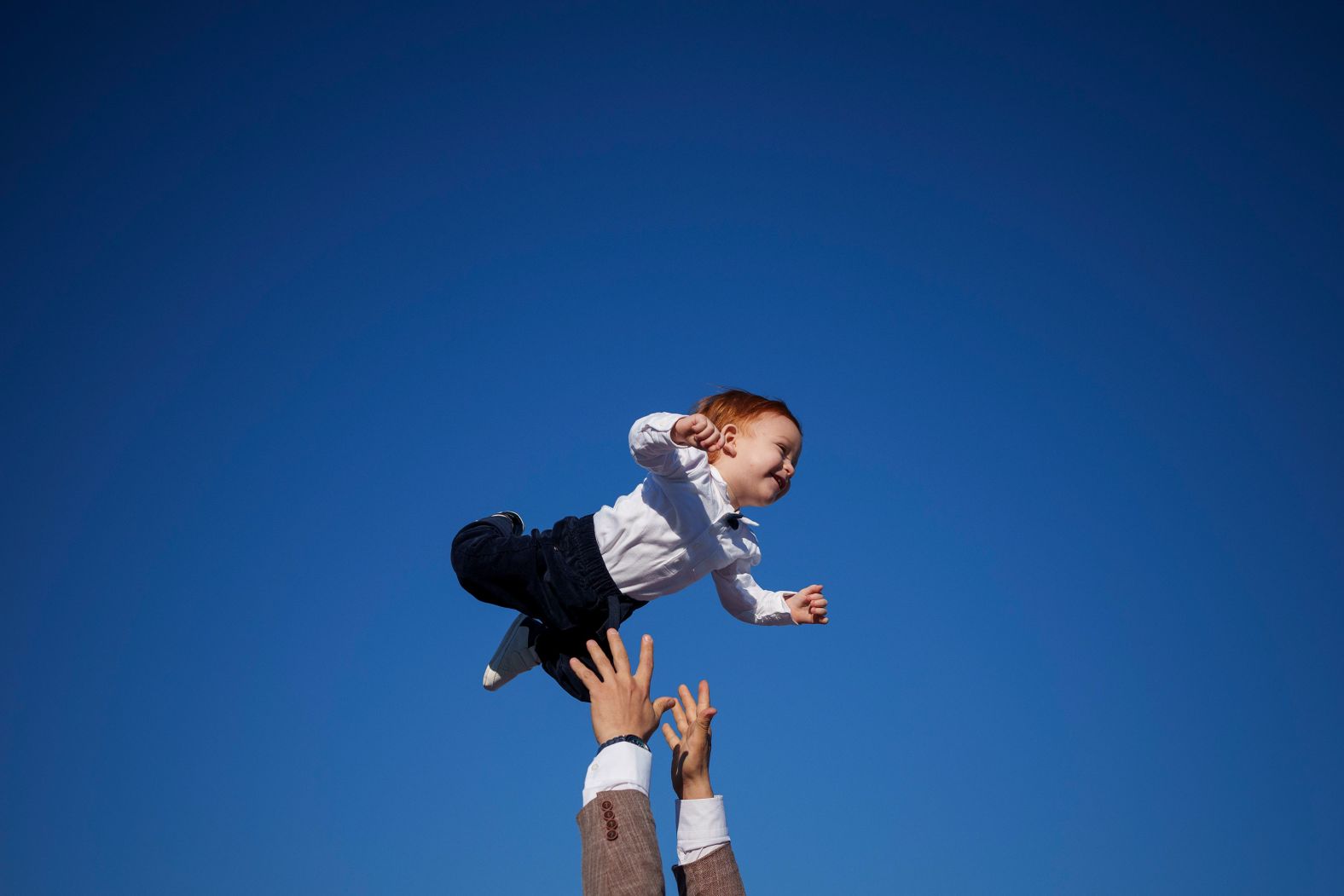 A Muslim man playfully throws a child into the air at the end of Eid al-Fitr prayers in Bucharest, Romania, on Wednesday, April 10. The Eid al-Fitr holiday marks the end of Ramadan.