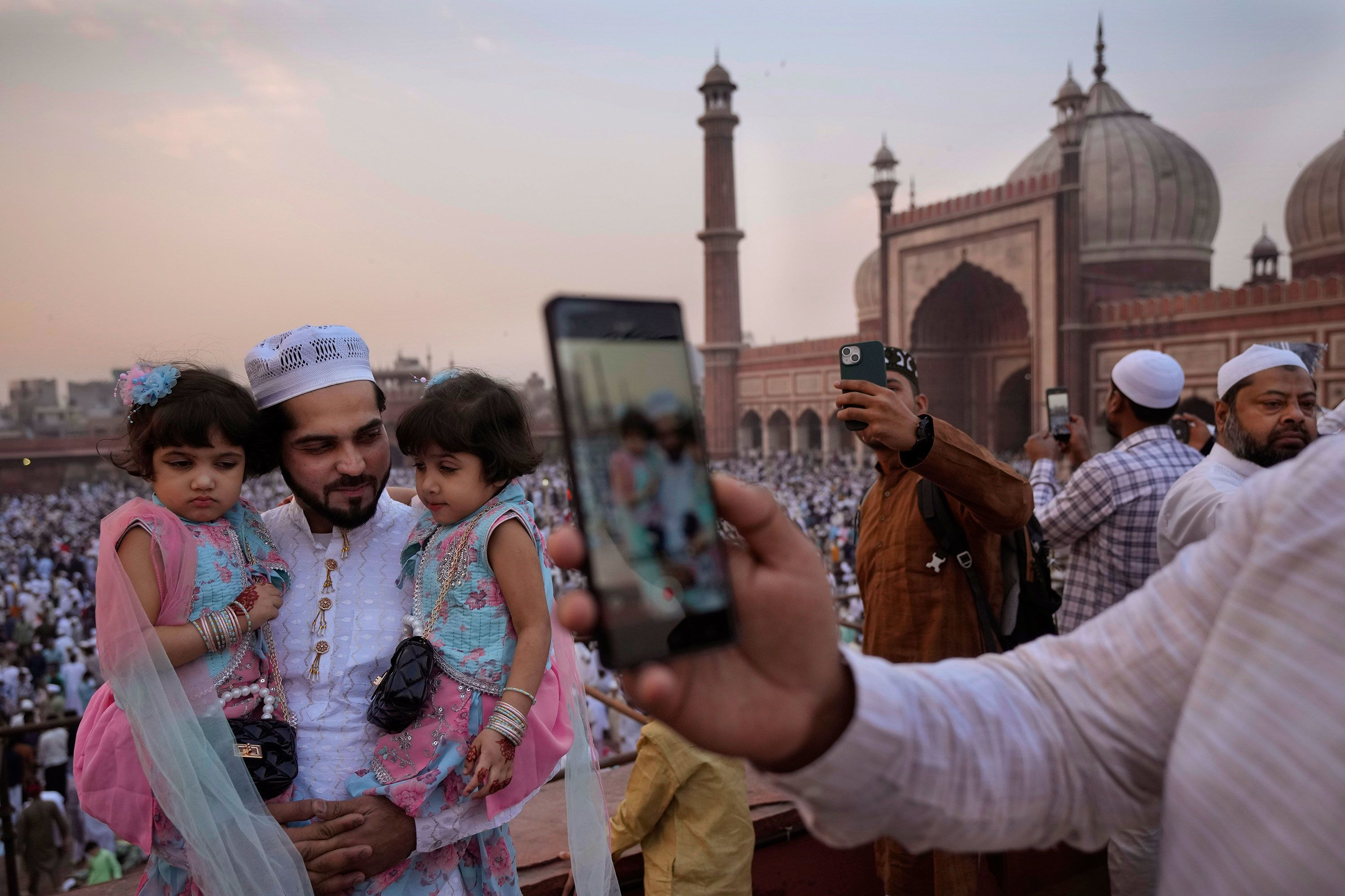 Muslims take selfies with their families after offering Eid al-Fitr prayer at Jama Masjid in New Delhi, India, on Thursday, April 11.