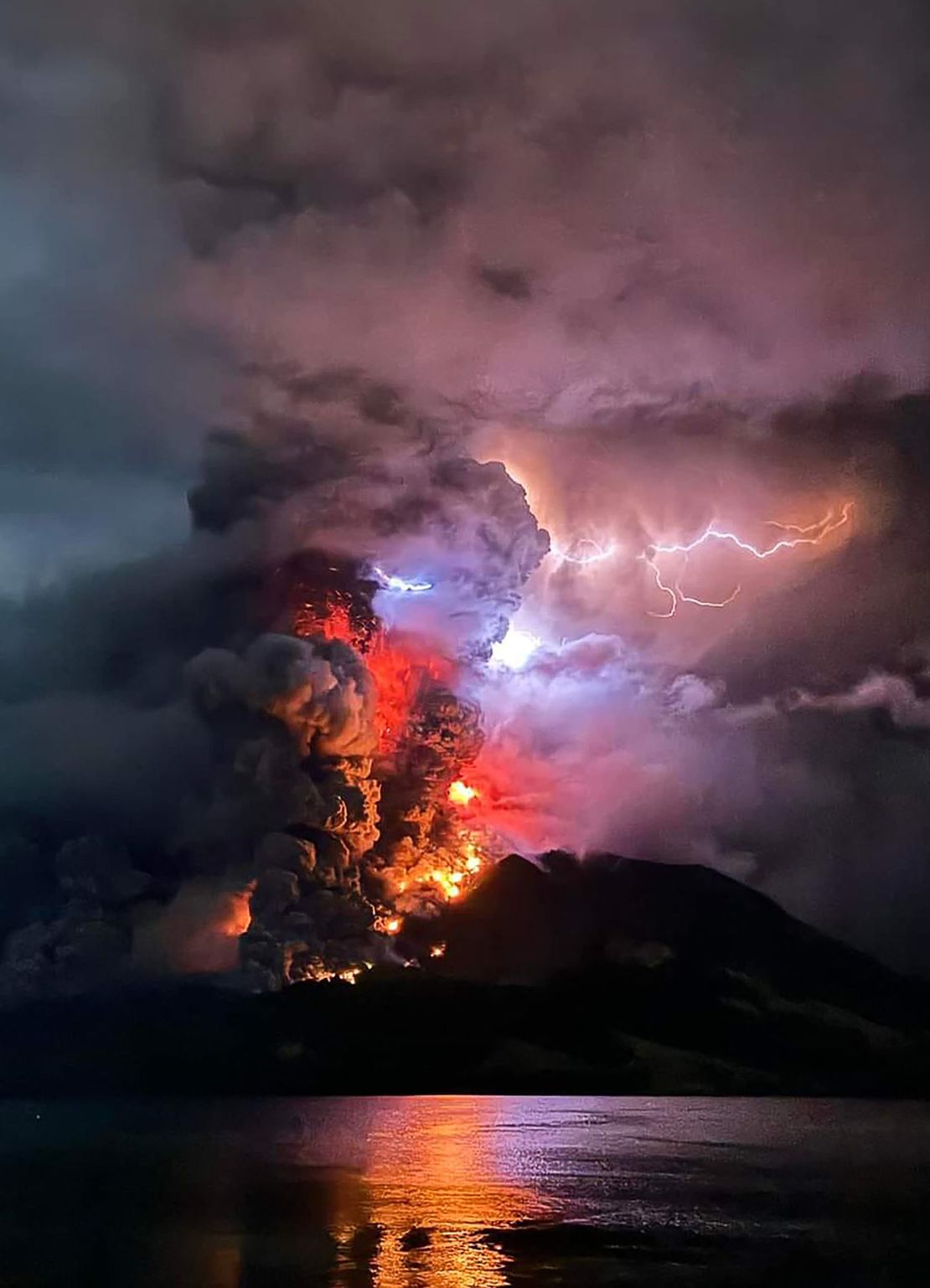 This handout photograph taken and released by the Center for Volcanology and Geological Hazard Mitigation on April 17, 2024 shows Mount Ruang spewing hot lava and smoke as seen
from Sitaro, North Sulawesi. A volcano erupted several times in Indonesia's outermost region overnight on April 17, forcing hundreds of people to be evacuated after it spewed lava and a
column of smoke more than a mile into the sky. Center for Volcanology and Geological Hazard Mitigation/AFP via Getty Images