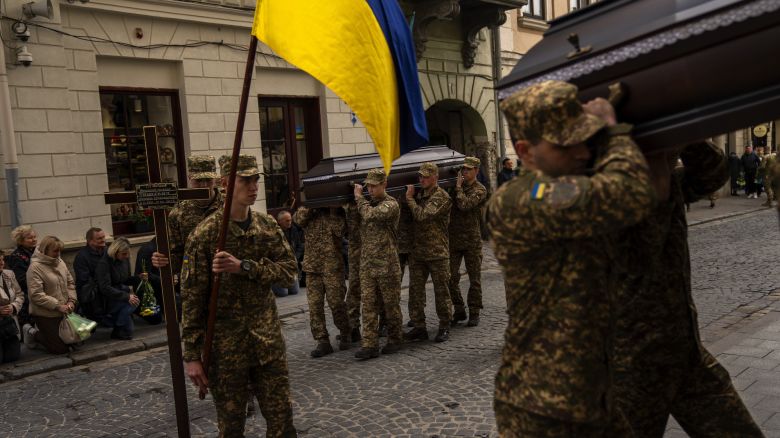Soldiers carry the coffins of two Ukrainian army sergeants Tomkevych Mykhailo and Kril Olexander during their funeral at the Saints Peter and Paul church in Lviv, Ukraine, Tuesday, April 16, 2024. (AP Photo/Francisco Seco)